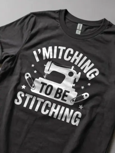 Lifestyle Shot Dark Heather shirt with fabric bundle – funny sewing machine t-shirt