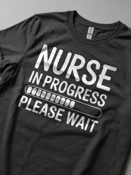 Front view of dark heather nurse in progress t-shirt with white text