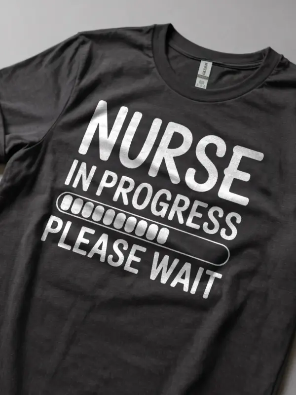 Front view of dark heather nurse in progress t-shirt with white text