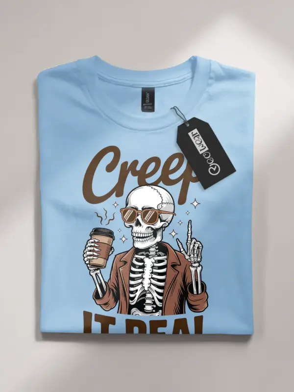 light blue flatlay front – Creep It Real retro funny skeleton coffee shirt