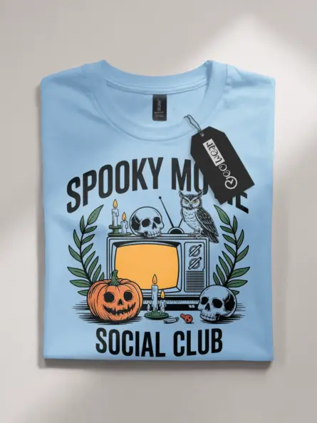 light blue flatlay spooky movie social club t-shirt – skulls, candles, and jack-o’-lantern