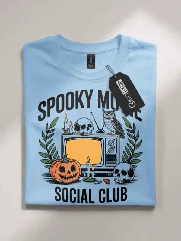 light blue flatlay spooky movie social club t-shirt – skulls, candles, and jack-o’-lantern