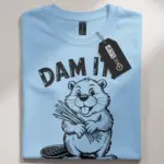 light blue shirt front with beaver illustration and dam it joke