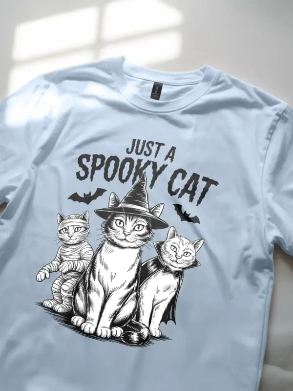 close-up – witch cat and bats on light blue spooky cat Halloween t-shirt